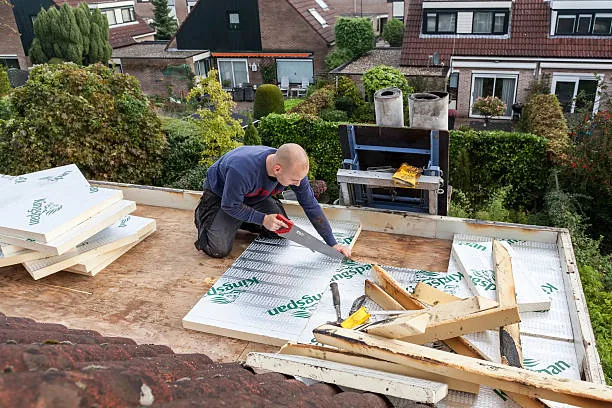 Dakdekker zaagt Kingspan PIR isolatieplaten op pannendak voor dakisolatie