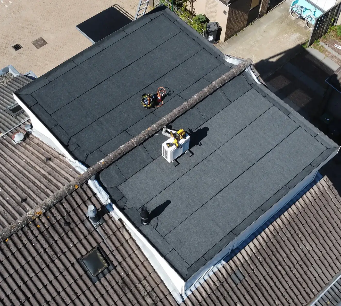 Dronefoto van twee vernieuwde platte daken met bitumen dakbedekking